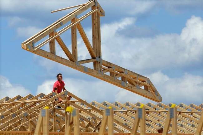 In this July 17, 2014 photo, construction workers build a commercial complex in Springfield, Ill. The government issues its first of three estimates of how fast the U.S. economy grew in the April-June quarter on Wednesday, July 30, 2014. (AP Photo/Seth Perlman)