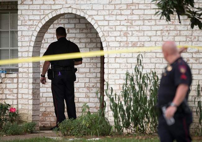 Law enforcement officers investigate the scene of a shooting Wednesday, July 9, 2014, in Spring, Texas. A Harris County Sheriff\’s Office statement says precinct deputy constables were called to a house about 6 p.m. Wednesday and found two adults and three children dead.