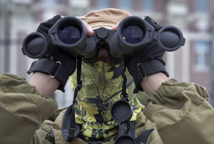 A Donetsk People's Republic fighter stands guard during a pro-Russian meeting in the city of Donetsk, eastern Ukraine Sunday, July 13, 2014. 
