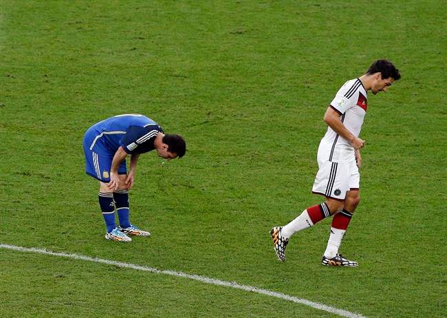 Argentina's Lionel Messi spits up as Germany's Mats Hummels walks by during the World Cup final soccer match between Germany and Argentina at the Maracana Stadium in Rio de Janeiro, Brazil, Sunday, July 13, 2014.