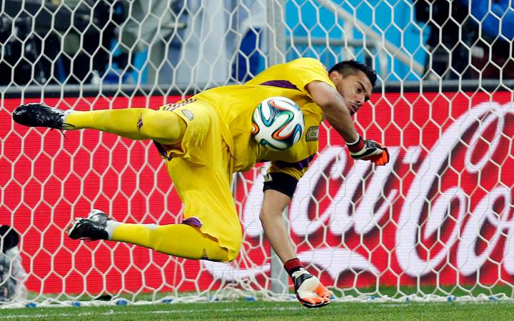 Argentina's goalkeeper Sergio Romero saves a shot from the penalty spot by Netherlands' Ron Vlaar in the shoot-out of the World Cup semifinal soccer match between the Netherlands and Argentina at the Itaquerao Stadium in Sao Paulo, Brazil, Wednesday, July 9, 2014.