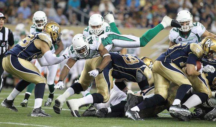 Tyron Brackenridge #41 of the Saskatchewan Roughriders goes airborne in an effort to stop make the stop against Robert Marve #16 of the Winnipeg Blue Bombers on Thursday in Winnipeg.