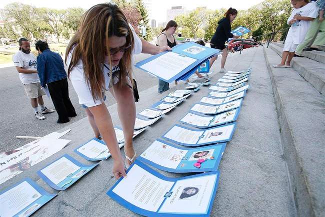 Bernadette Smith, the sister of Claudette Osborne who has been missing since 2008, lays placards of 94 women who have been murdered or are missing in Manitoba, at the Manitoba Legislature in 2009.
