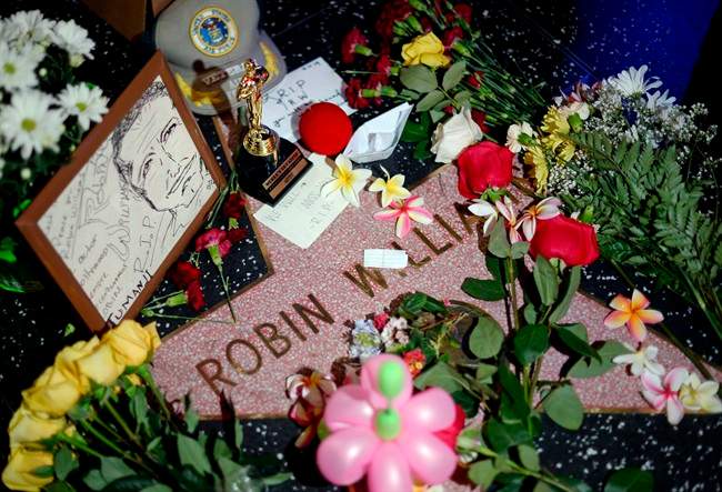 Flowers are placed in memory of Robin Williams on his Walk of Fame star in the Hollywood district of Los Angeles Monday, Aug. 11, 2014.