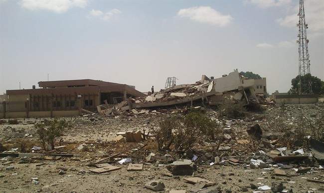 A man stands on the rubble of the main building of the security headquarters that was collapsed after an attack by Islamic hard-line militias in Benghazi, Libya, Friday, Aug. 1, 2014. Islamic hard-line militias, including the group accused by the United States in a 2012 attack that killed the ambassador and three other Americans, claimed control of Libya's second largest city, Benghazi, after overrunning army barracks and seizing heavy weapons.