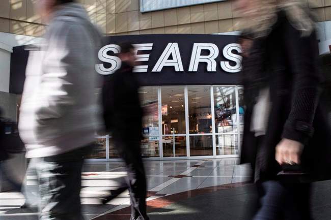 Commuters walk past a Sears store in Toronto.
