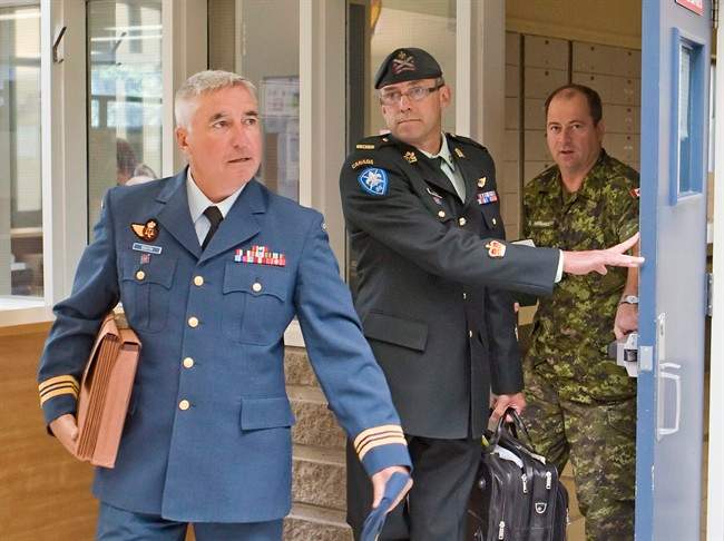 Warrant officer Andre Gagnon, centre, walks to testify at his court martial at the St-Malo Armoury Tuesday, August 12, 2014 in Quebec City with his defence counsel Major Philippe-Luc Boutin, left. 