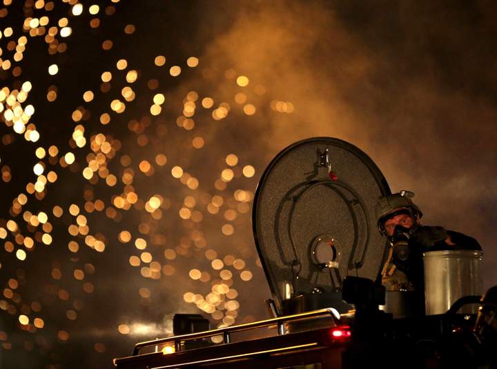 A law enforcement officer on a tactical vehicle watches after a device was fired to disperse a crowd Sunday, Aug. 17, 2014, during a protest for Michael Brown, who was killed by a police officer last Saturday in Ferguson, Mo. As night fell Sunday in Ferguson, another peaceful protest quickly deteriorated after marchers pushed toward one end of a street. Police attempted to push them back by firing tear gas and shouting over a bullhorn that the protest was no longer peaceful.