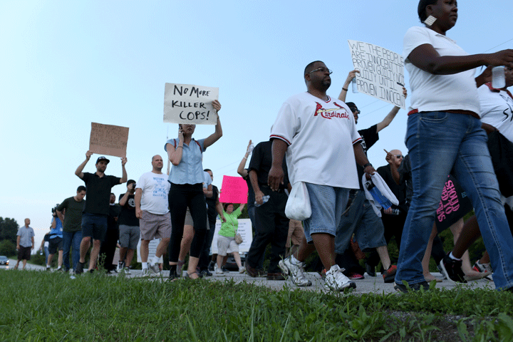 Demonstrators protesting the shooting death of Michael Brown march through the streets with signs critical of the police force on August 20, 2014 in Ferguson, Missouri.