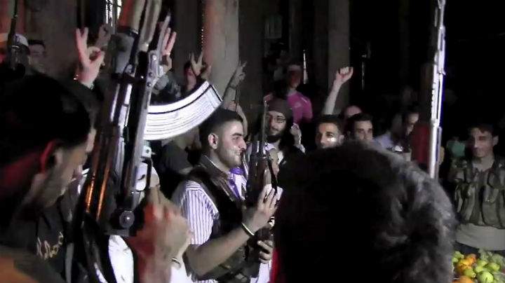 An image grab taken from AFP TV shows Syrian rebel sniper Abu Khaled (C) holding his gun as comrades celebrate during his wedding ceremony in the Saif al-Dawla district of the northern city of Aleppo on August 31, 2012.