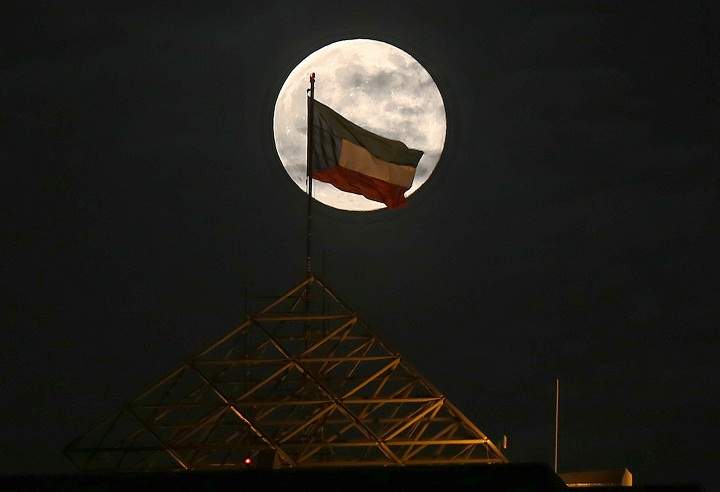 The "supermoon" is seen rising above the Kuwait skyline on August 10, 2014.