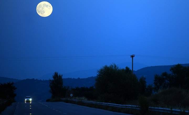 The full moon, nicknamed "the supermoon", rises over road near the town of Bitola on August 10, 2014.