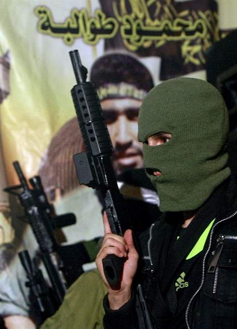 In this Wednesday, Aug. 20, 2014 Photo, A Palestinian militant holds his weapon during a protest against Israeli operations on the Gaza strip, in the West Bank refugee camp of Jenin. (AP Photo/Mohammed Ballas).