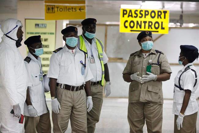 Nigeria health officials wait to screen passengers at the arrival hall of Murtala Muhammed International Airport in Lagos, Nigeria, Monday, Aug. 4, 2014. 