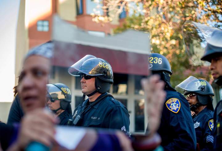 A demonstrator holds a mirror up to police officers forming a containment line in Oakland, Calif. on Wednesday, Aug. 20, 2014 during a protest by several hundred against the shooting of Michael Brown. AP Photo/Noah Berger