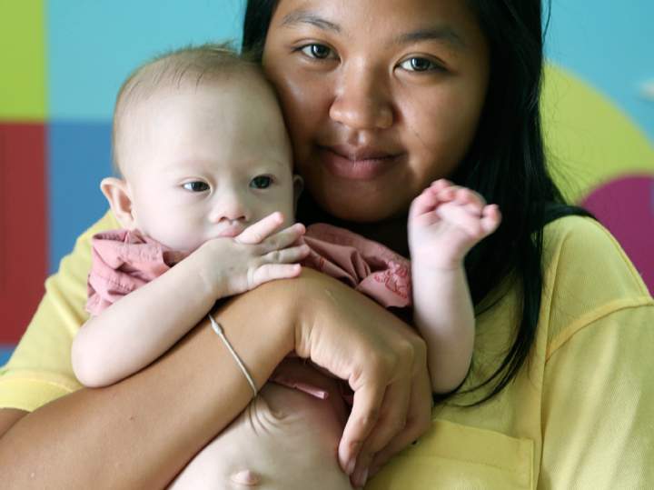 Pattaramon Chanbua, 21, poses her baby boy Gammy at a hospital in Chonburi province, southeastern Thailand Sunday, Aug. 3, 2014. 