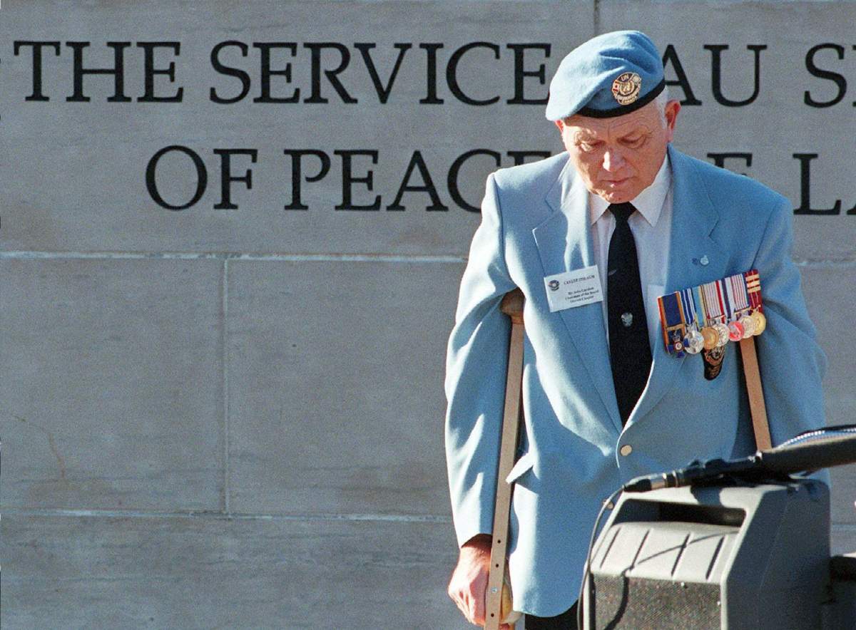Peacekeeping veteran retired Col. John Gardam bows his head during a minute of silence at a ceremony held at the Peacekeeping monument in Ottawa .