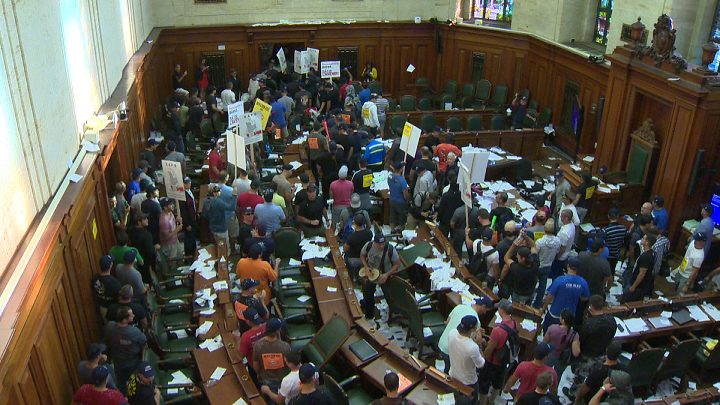 Protesters against Bill 3 storm city hall on August 18, 2014.
