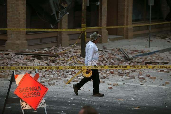 A worker walks by rubble