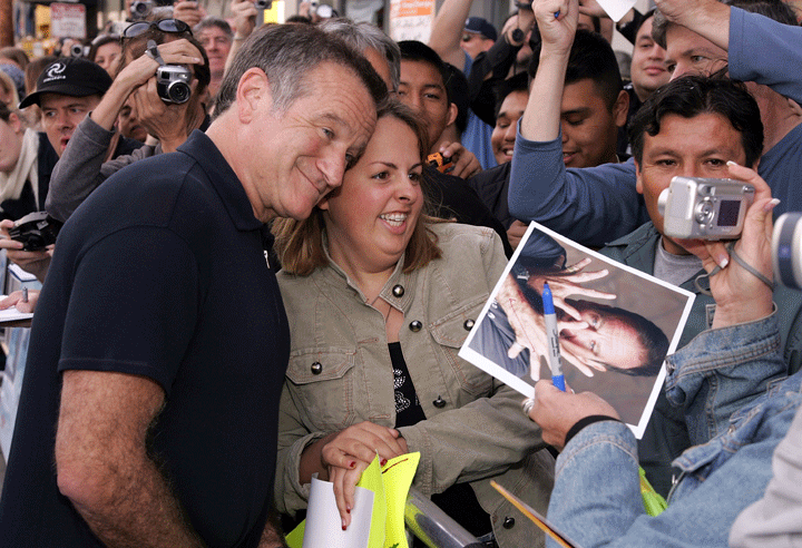 r Robin Williams signs autographs as he arrives to the Warner Bros. film premiere of Happy Feet held at Grauman’s Chinese Theater November 12, 2006 in Hollywood, California.