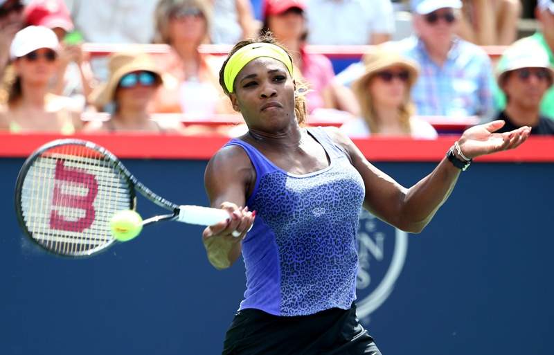 Serena Williams of the USA returns a shot to Venus Williams of the USA during the women's semifinals match in the Rogers Cup at Uniprix Stadium on August 9, 2014 in Montreal, Canada. (Photo by Streeter Lecka/Getty Images).