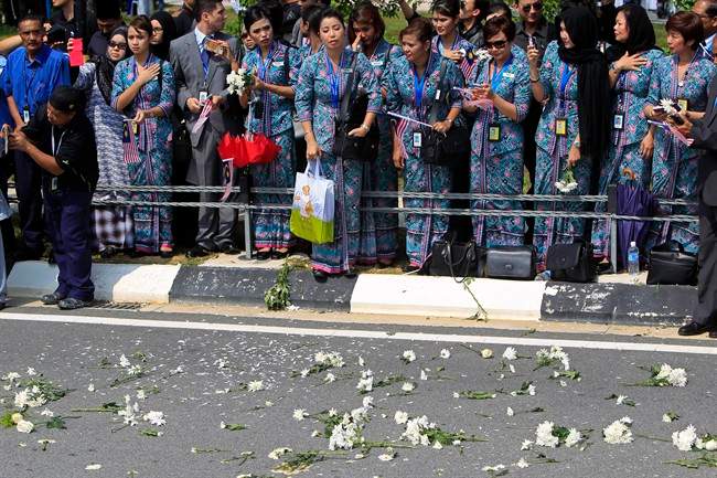Flowers are laid along a roadside after hearses carrying victims' bodies of the ill-fated Malaysia Airlines Flight MH17 leaved Bunga Raya Complex at Kuala Lumpur International Airport in Sepang, Malaysia, Friday, Aug. 22, 2014.