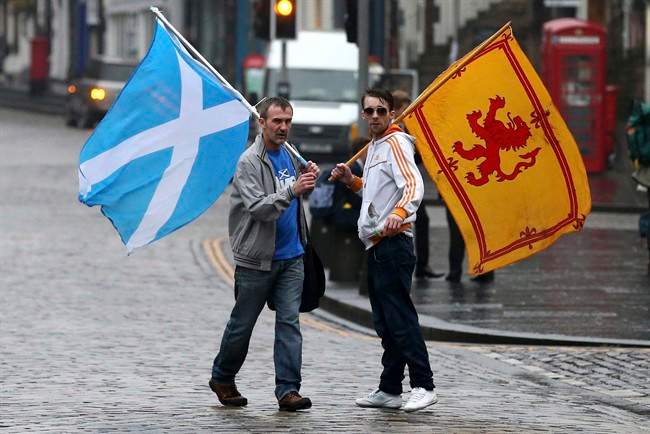 Supporters of the Yes campaign for the Scottish independence referendum stand on the Royal Mile in Edinburgh, Scotland, Friday, Sept. 19, 2014. THE CANADIAN PRESS/AP, Scott Heppell.