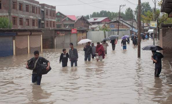 Kashmiris walk through a flooded area to a safer place on September 04, 2014 in Srinagar, the summer capital of Indian administered Kashmir, India.  The floods in the Himalayan region are believed floods to be the worst in decades, killing 15 people and and affecting some 50,000 families.