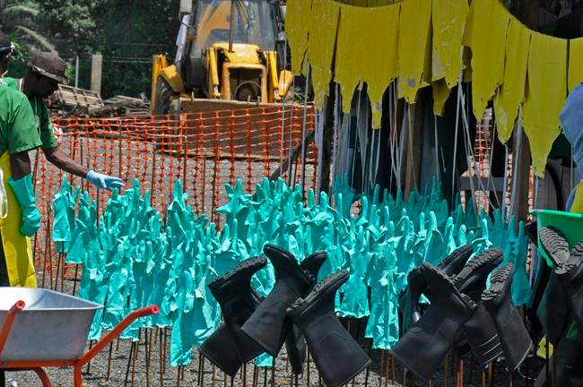 Gloves and rubber boots forming part of the Ebola prevention gear for health workers at a clinic are set outside for the sun to dry them after being washed in Monrovia, Liberia, Monday, Sept. 8, 2014. 