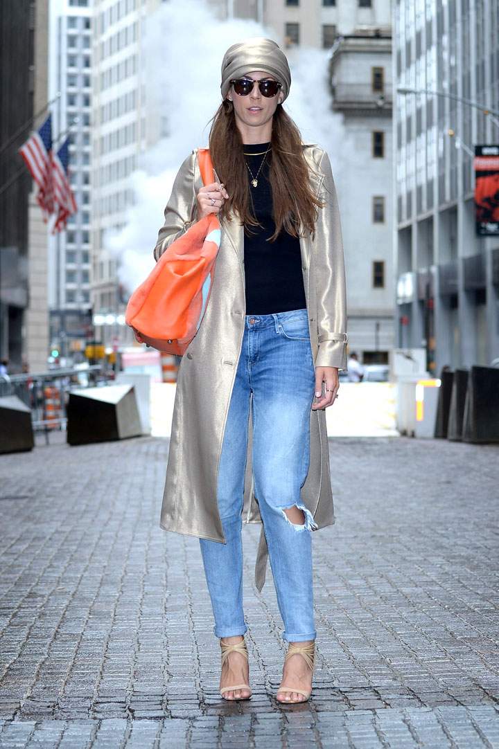 Blogger for www.BONDmrkt.com is seen wearing a GEORGINE gold silk trench coat, turban and bag, along with her own H&M jeans, Mark & James by Badgley Mischka heels, necklace by Jennifer Fisher, sunglasses and rose-shaped earrings in white gold on Wall Street on September 9, 2014 in New York City during Mercedes-Benz Fashion Week Spring 2015.