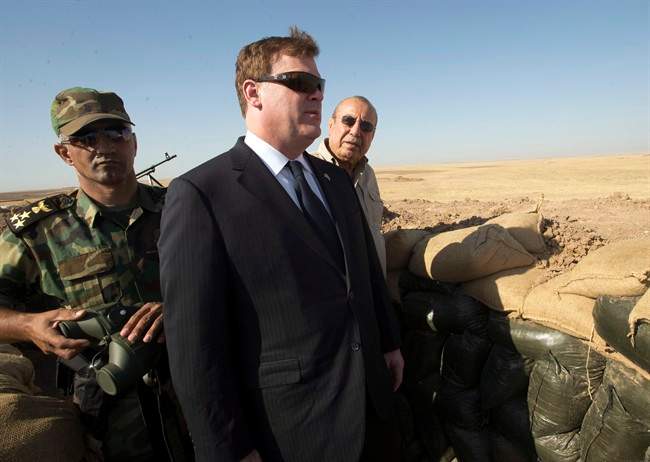 Canadian Foreign Affairs Minister John Baird, centre, and Iraqi Deputy Minister Rowsch Nouri Sharways look at ISIS positions from a front line bunker Thursday, Sept. 4, 2014 in Kalak, Iraq.