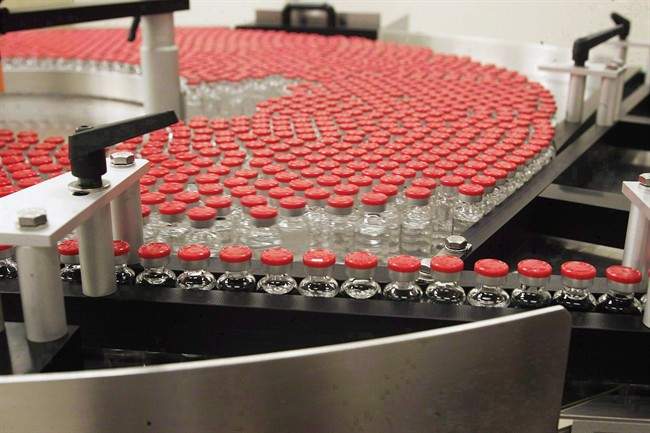 Bottles of flu vaccine on an assembly line