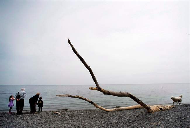 Families take in the warm weather on Lake Ontario at Humber Bay Park in Toronto on Monday, April 21, 2014.