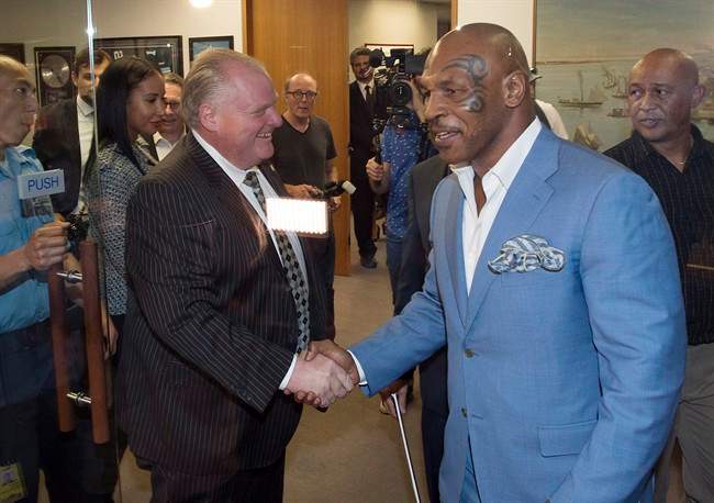 Toronto Mayor Rob Ford, centre, shakes hands with former heavyweight boxing champion Mike Tyson at City Hall in Toronto on Tuesday, September 9, 2014. 