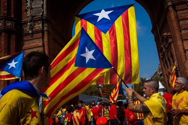 People wave “estelada” flags symbolizing Catalonia's independence in Barcelona, Spain, Thursday, Sept. 11, 2014. The region has set an Oct. 1, 2017 referendum vote to decide whether to split from Spain.