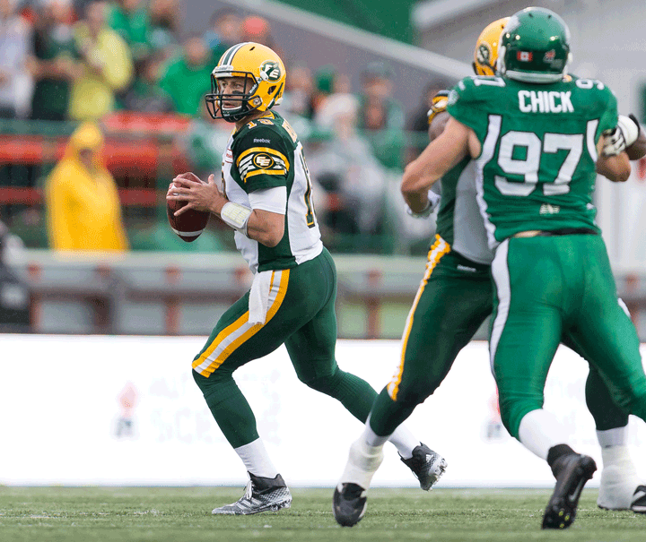 Mike Reilly #13 of the Edmonton Eskimos drops back to pass during a pre-season game between the Edmonton Eskimos and Saskatchewan Roughriders at Mosaic Stadium on June 20, 2014 in Regina, Saskatchewan, Canada.