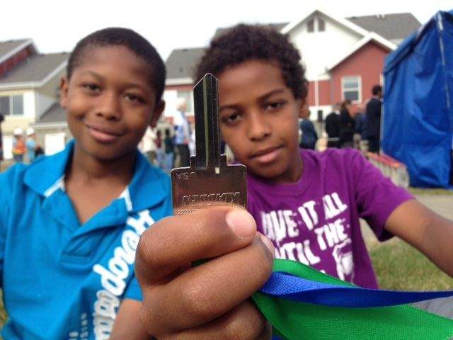 Trai Carter (left) and Johnny Teclemaram (right) proudly show off one of the keys to their new homes.