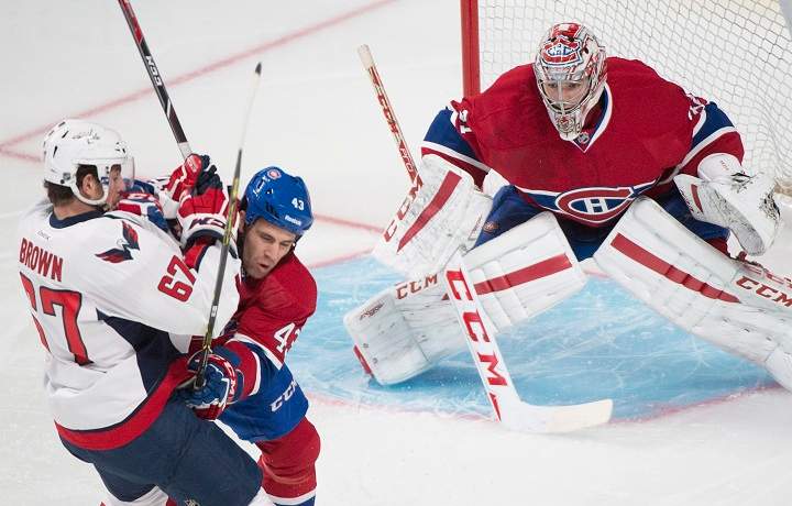 Montreal Canadiens' goaltender Carey Price (31) keeps an eye on the play as Canadiens' Mike Weaver (43) defends against Washington Capitals' Chris Brown(67) during first period NHL pre-season hockey action in Montreal, Sunday, September 28, 2014.