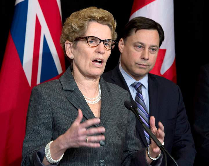Ontario Premier Kathleen Wynne (left) speaks and Minister of Training, Colleges and Universities Brad Duguid listens after meeting with education representatives at Queen's Park in Toronto Thursday, March 27, 2014.