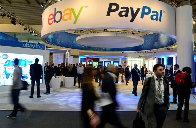 Attendees walk in front of an EBay and PayPal display area at the Mobile World Congress, the world's largest mobile phone trade show, in Barcelona, Spain. PayPal is splitting from EBay Inc. and will become a separate and publicly traded company during the second half of 2015.
