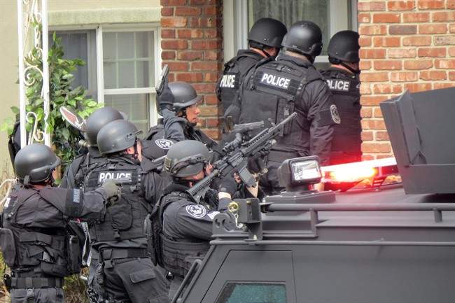 In this April 22, 2014, file photo, Nassau County police officers enter a home in Long Beach, N.Y., in search of an armed killer, based on a phone call that turned out to be a hoax.