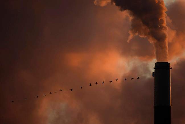  In this Saturday, Jan. 10, 2009, file photo, a flock of geese fly past a smokestack at the Jeffery Energy Center coal power plant near Emmitt, Kan.