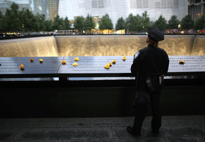 NY-Port Authority Police Officer Donna Przybyszewski spent a moment to think about her colleagues she knew who lost their lives during September 11th attack in 2001, at the South Tower Memorial Pool before memorial observances held at the site of the World Trade Center in New York, Sept. 11, 2014. (Photo credit: AP Photo/POOL, Credit: Chang W. Lee)