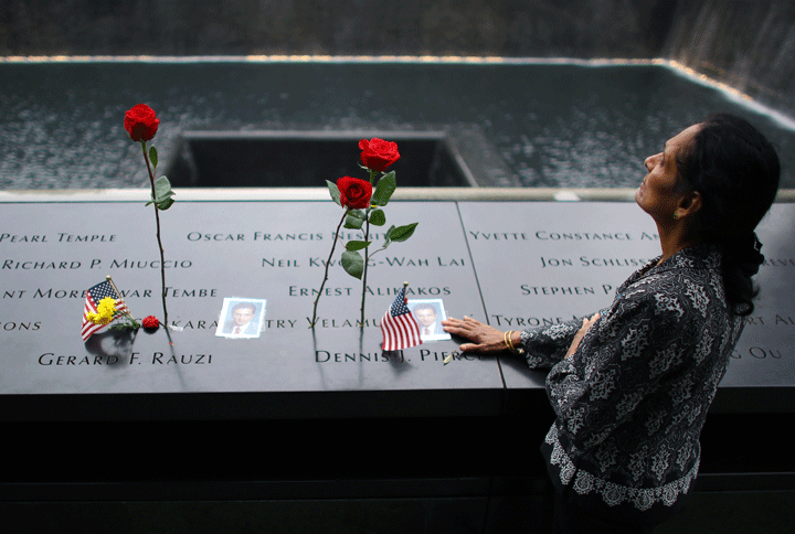A woman grieves at her husband’s memorial at South Tower Memorial Pool during memorial observances on the 13th anniversary of the Sept. 11 terror attacks on the World Trade Center in New York, Thursday, Sept. 11, 2014. (Photo credit: AP Photo/The New York Times, Chang W. Lee, Pool)
