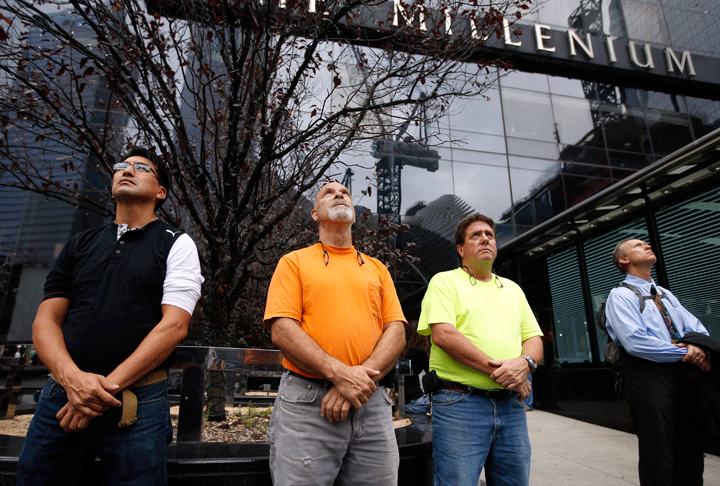 From left, Rody Cabezas, of Nutley, N.J., Rick Talcovitz, of Mahopak, N.Y., Tom Cooley, of Leavittown, N.Y., and Fletcher McBeth, of Jersey City, N.J., look up at 1 World Trade Center during a moment of silence on the 13th anniversary of the Sept. 11, 2001 attacks, Thursday, Sept. 11, 2014, in New York. (Photo credit: AP Photo/Jason DeCrow)