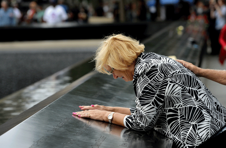 Paola Braut, of Belgium, cries over a photograph of her son Patrice along the edge of the North Pool during memorial observances on the 13th anniversary of the Sept. 11 terror attacks on the World Trade Center in New York. (Photo credit: AP Photo/Justin Lane, Pool)