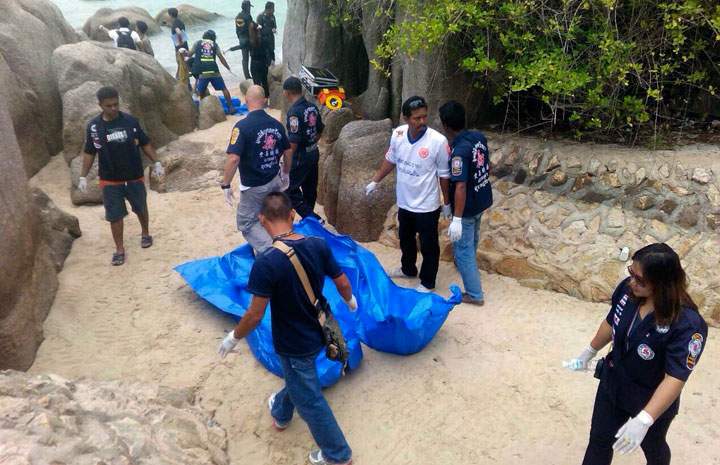 Thai officers walk near the bodies of two British tourists Monday, Sept. 15, 2014 on a beach in Surat Thani province, southern Thailand.