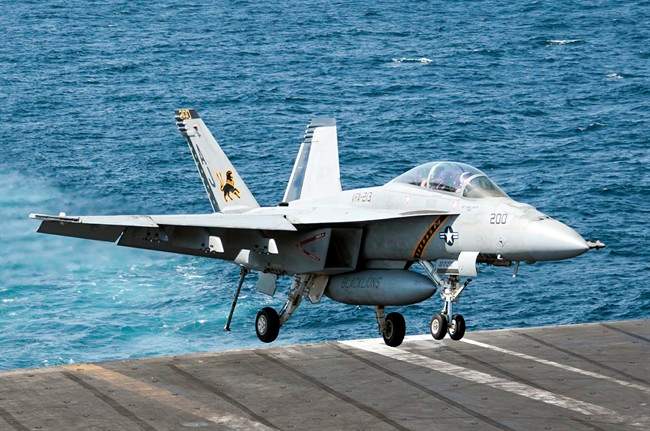 In this image provided by the U.S. Navy a F/A-18F Super Hornet attached to the Fighting Black Lions of Strike Fighter Squadron lands aboard the aircraft carrier USS George H.W. Bush in the Persian Gulf on Tuesday, Sept. 23, 2014, after conducting strike missions against Islamic State group targets in Syria.