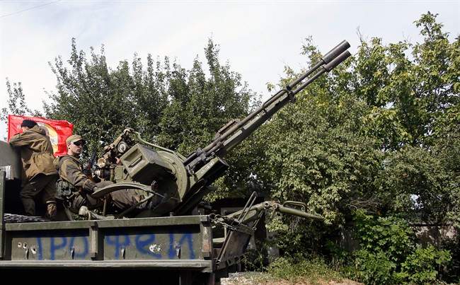 A Pro-Russian rebels truck with an anti-aircraft weapon is driven in a parade in the town of Luhansk, eastern Ukraine, Sunday, Sept. 14, 2014.