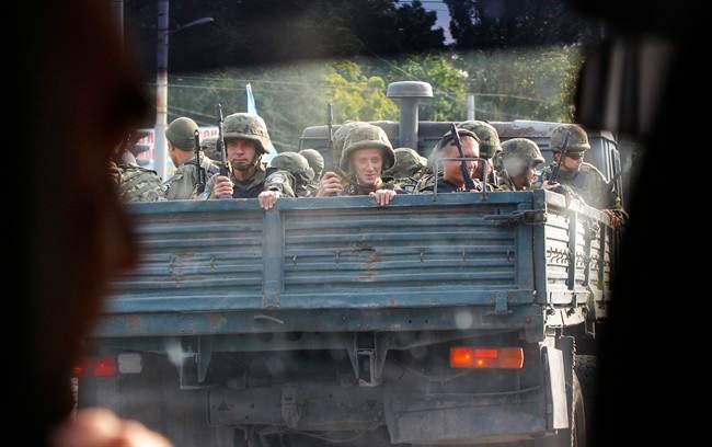 Ukrainian soldiers drive on a truck in the southern coastal town of Mariupol, Ukraine, Monday, Sept. 8, 2014. 